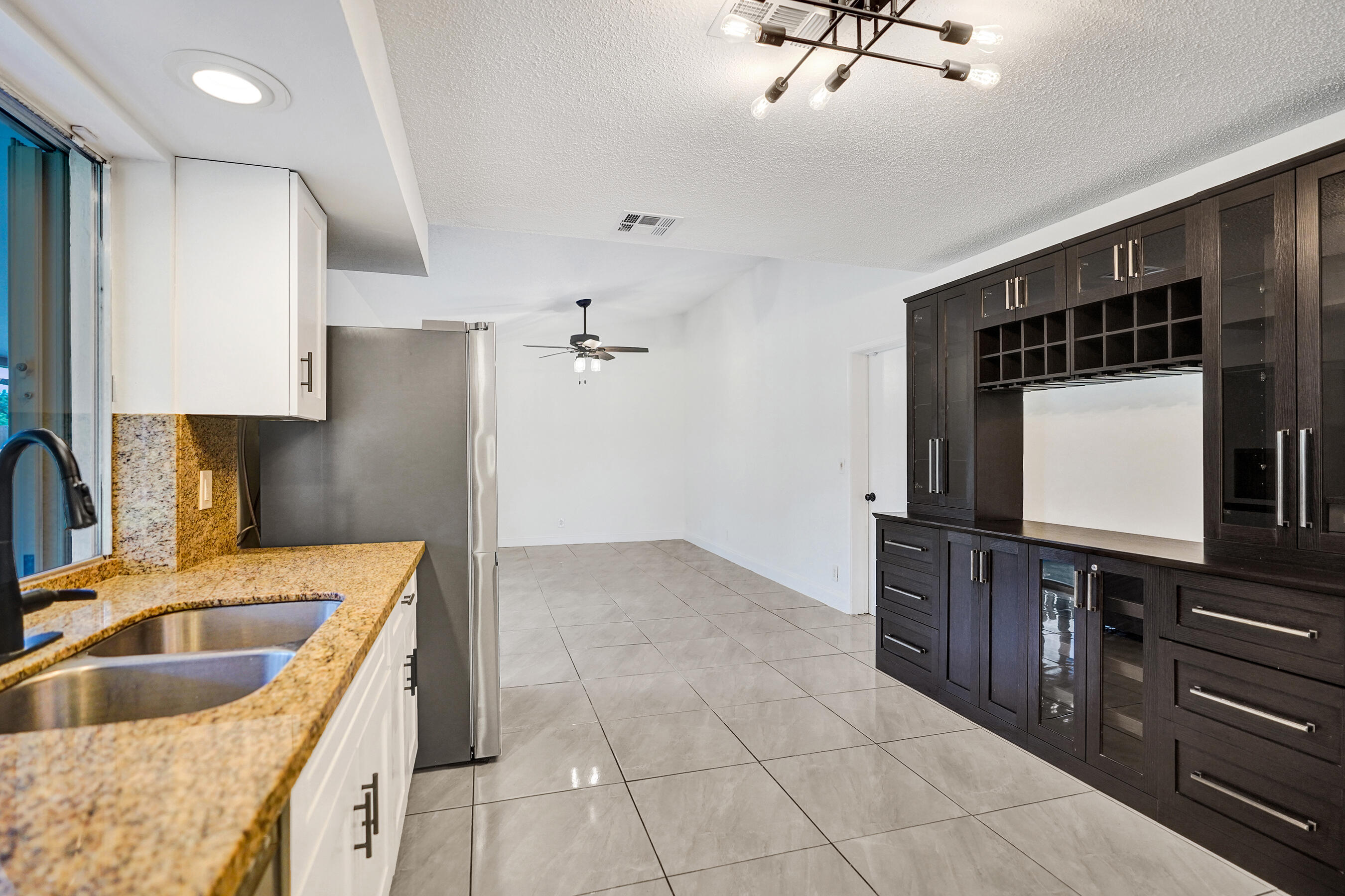 9855 Robins Nest Road Boca Raton, FL 33496 - Photo 10 of 84 a kitchen with kitchen island granite countertop a sink stove and refrigerator