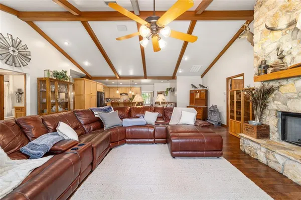a kitchen with stainless steel appliances kitchen island granite countertop a refrigerator a stove a sink dishwasher and white cabinets with wooden floor