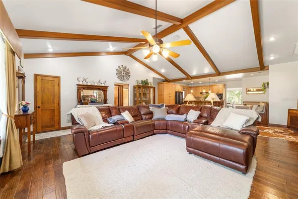a kitchen with stainless steel appliances kitchen island granite countertop a refrigerator a stove and white cabinets with wooden floor