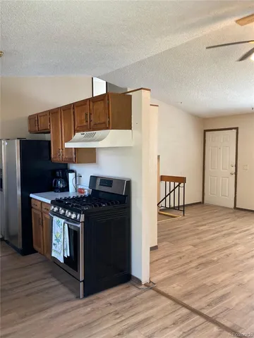 a kitchen with stainless steel appliances a stove refrigerator and cabinets