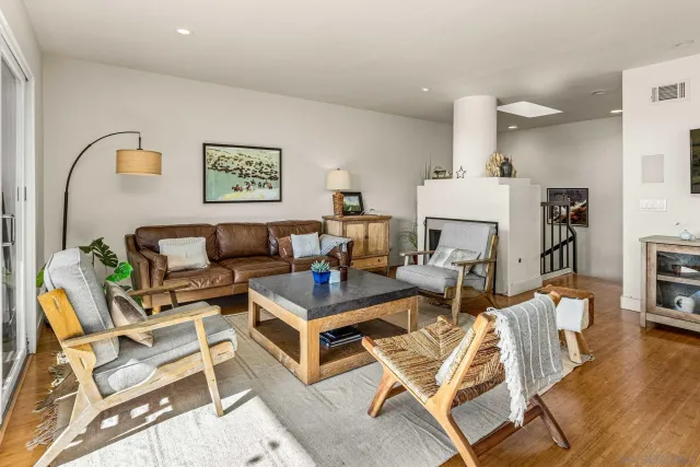 a living room with a couch and a dining table with wooden floor