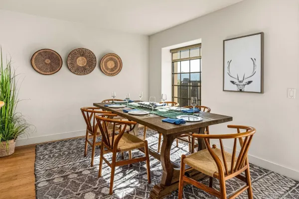 a kitchen with stainless steel appliances granite countertop a dining table chairs and granite counter tops