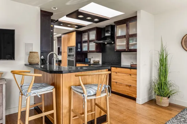 a large kitchen with stainless steel appliances a sink and cabinets