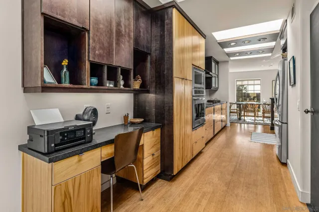 a kitchen with granite countertop a stove a sink and a wooden cabinets