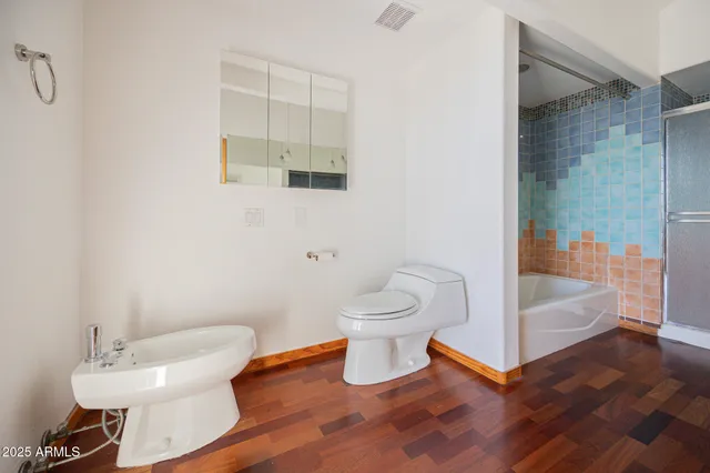 a bathroom with a toilet and a shower
