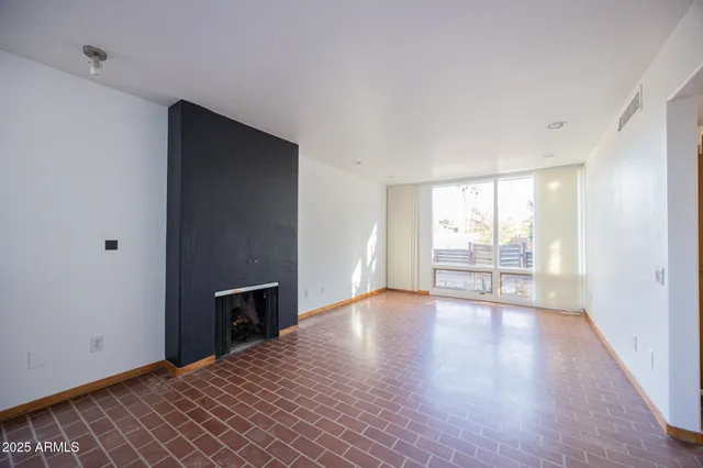 a view of a livingroom with wooden floor and a kitchen