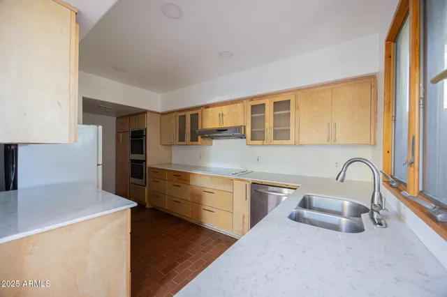 a kitchen with stainless steel appliances a sink a stove and a refrigerator with wooden floor