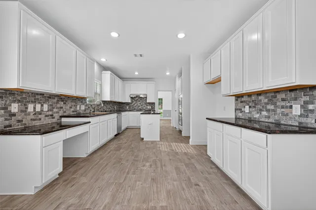 a kitchen with granite countertop a sink and cabinets