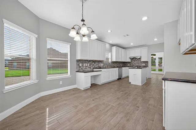 a large white kitchen with a refrigerator a stove a sink and a window