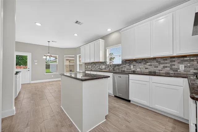 a kitchen with granite countertop a sink and cabinets