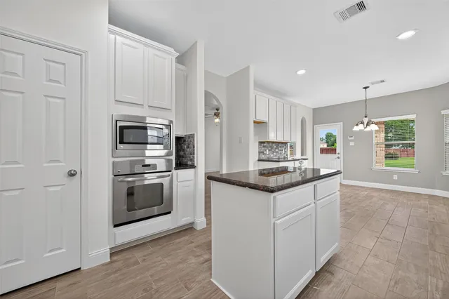 a kitchen with stainless steel appliances granite countertop a stove and a refrigerator