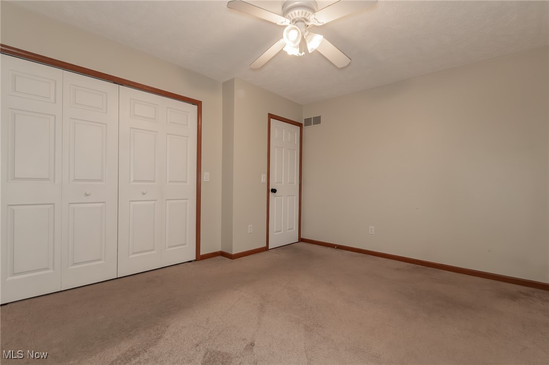 4815 South Ridge Road Perry, OH 44081 - Photo 32 of 48 Unfurnished bedroom with a closet, carpet, and a ceiling fan