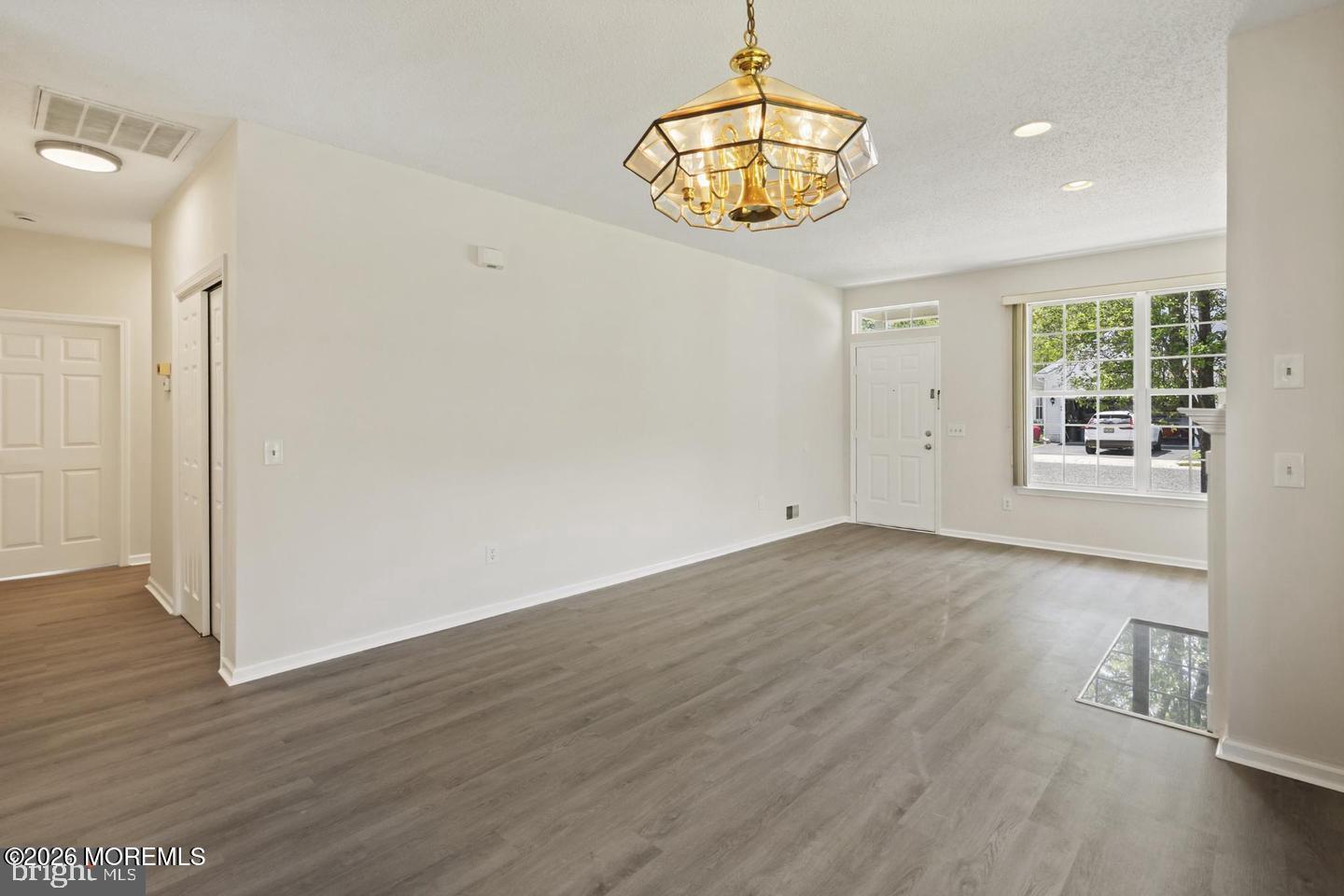 43 Osprey Place Barnegat, NJ 08005 - Photo 17 of 34 an empty room with wooden floor and chandelier