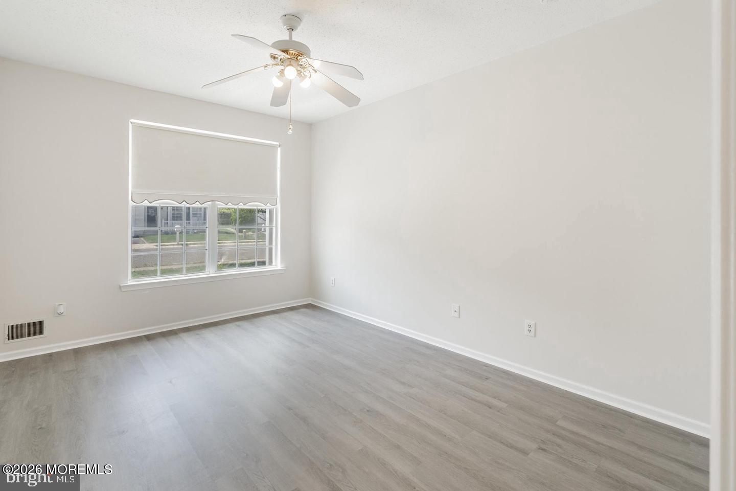 43 Osprey Place Barnegat, NJ 08005 - Photo 24 of 34 an empty room with wooden floor chandelier fan and windows