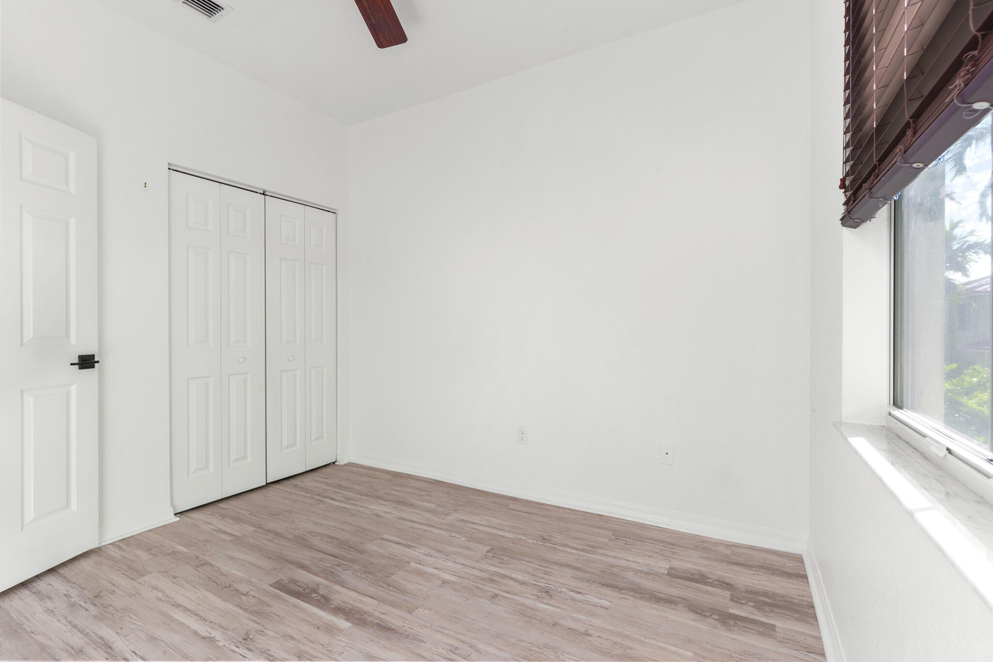 155 Monterey Bay Drive Boynton Beach, FL 33426 - Photo 24 of 37 a view of an empty room with wooden floor and a window