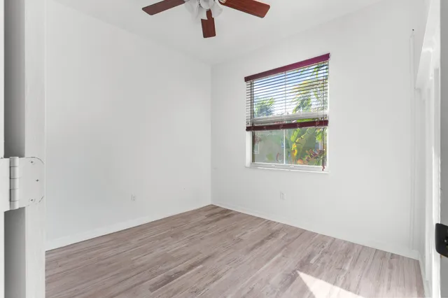 an empty room with a window and wooden floor