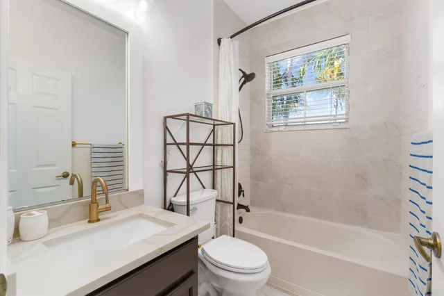 a bathroom with a sink toilet vanity and shower