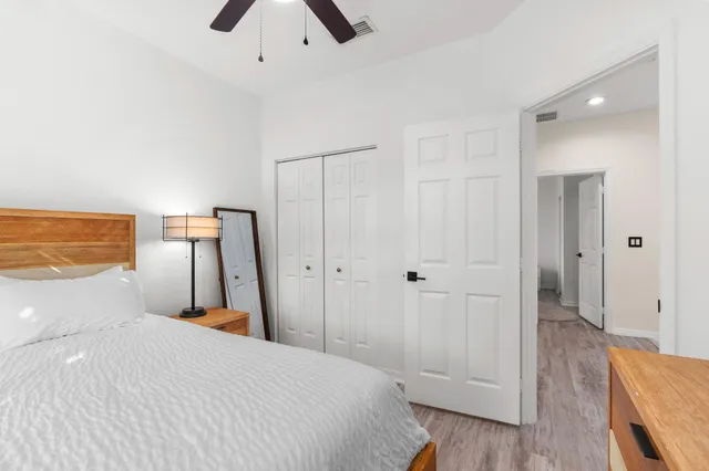 a bedroom with a bed and a flat tv screen on a dresser