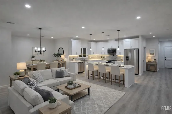 a living room with lots of furniture and kitchen view