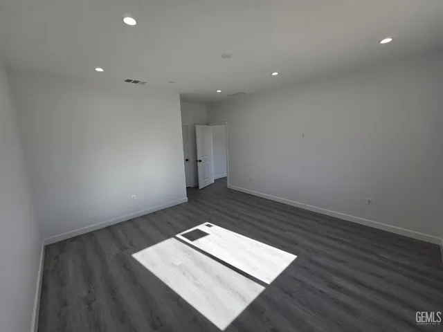 a view of an empty room with wooden floor