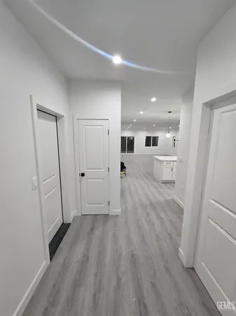 a large white kitchen with stainless steel appliances kitchen island granite countertop a sink and cabinets