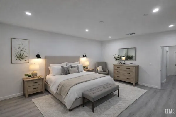 a spacious bedroom with a bed and lamp