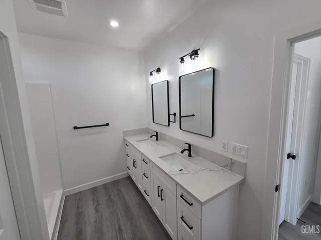 a bathroom with a double vanity sink and mirror