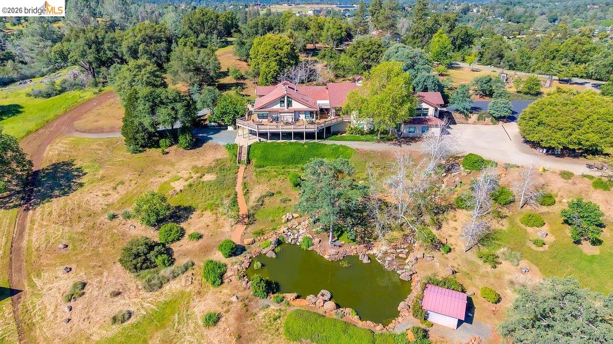 13700 Clements Road Groveland, CA 95321 - Photo 85 of 93 Expansive property featuring a multi-level residence with a large elevated deck, a natural-style pond, and mature landscaping