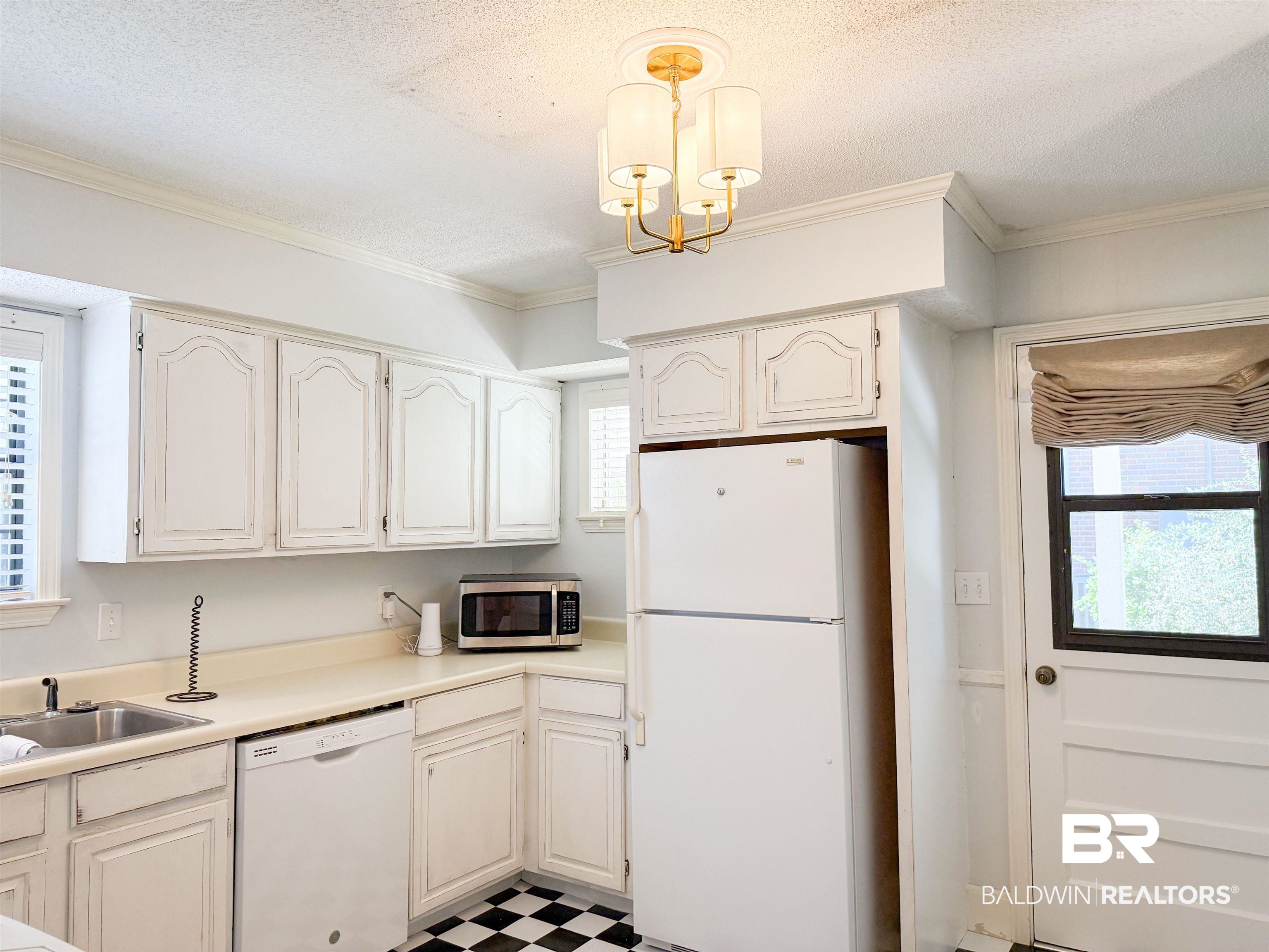1508 Poplar Avenue Brewton, AL 36426 - Photo 10 of 22 Kitchen with white appliances, light countertops, ornamental molding, a textured ceiling, and pendant lighting