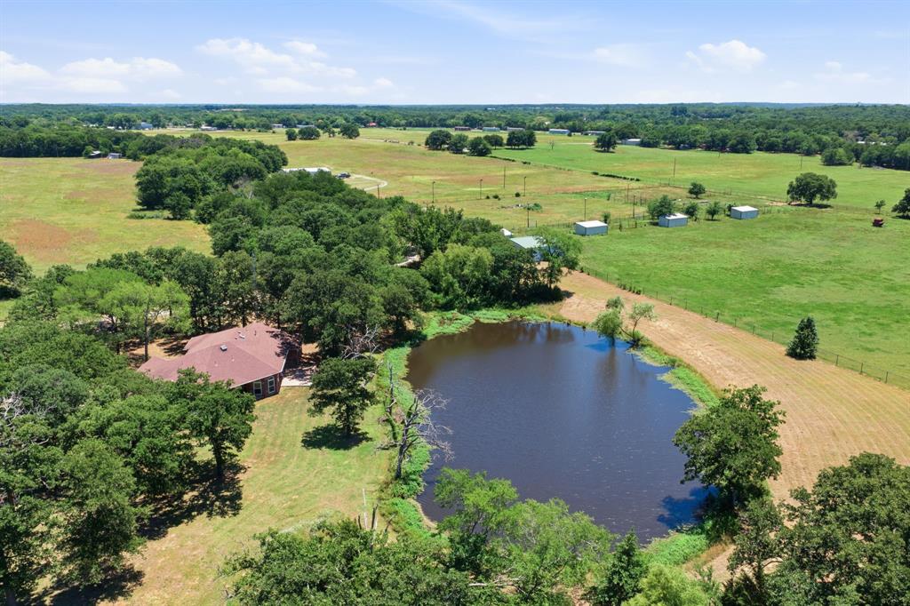 321 Cr 211 Road Gainesville, TX 76240 - Photo 26 of 40 Aerial view from the pond looking toward the loafing shed and arena.
