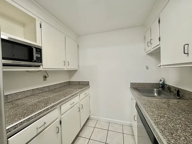 a kitchen with granite countertop a sink and cabinets