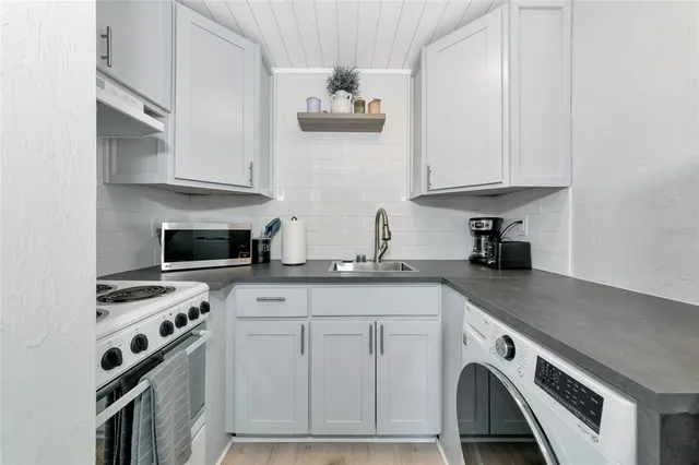 a kitchen with stainless steel appliances a sink a stove and cabinets