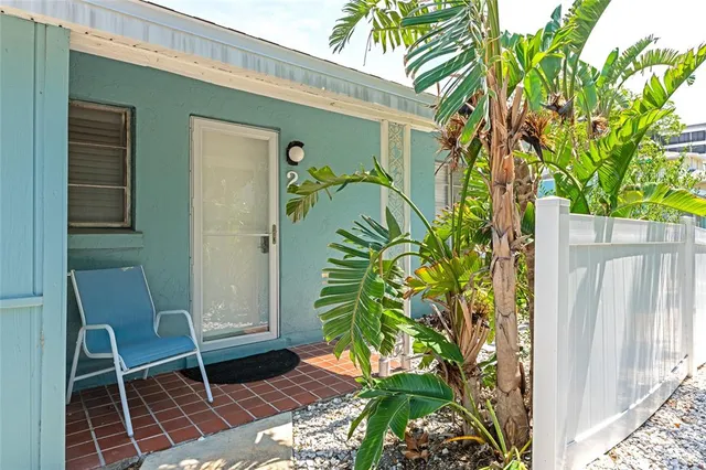 a backyard of a house with potted plants and large tree