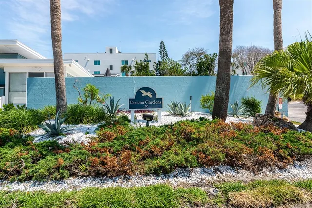 a front view of a house with a garden and trees