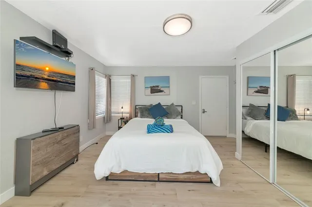 a bed room with a bed and a view of kitchen