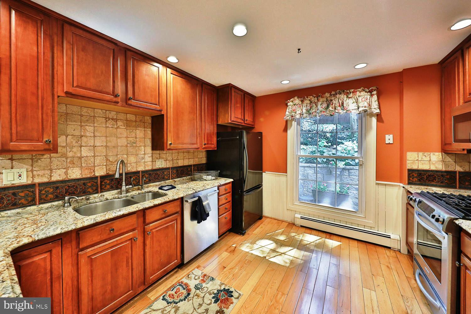 923 Rydal Road Jenkintown, PA 19046 - Photo 16 of 56 a kitchen with stainless steel appliances granite countertop a stove a sink dishwasher and a refrigerator with wooden floor