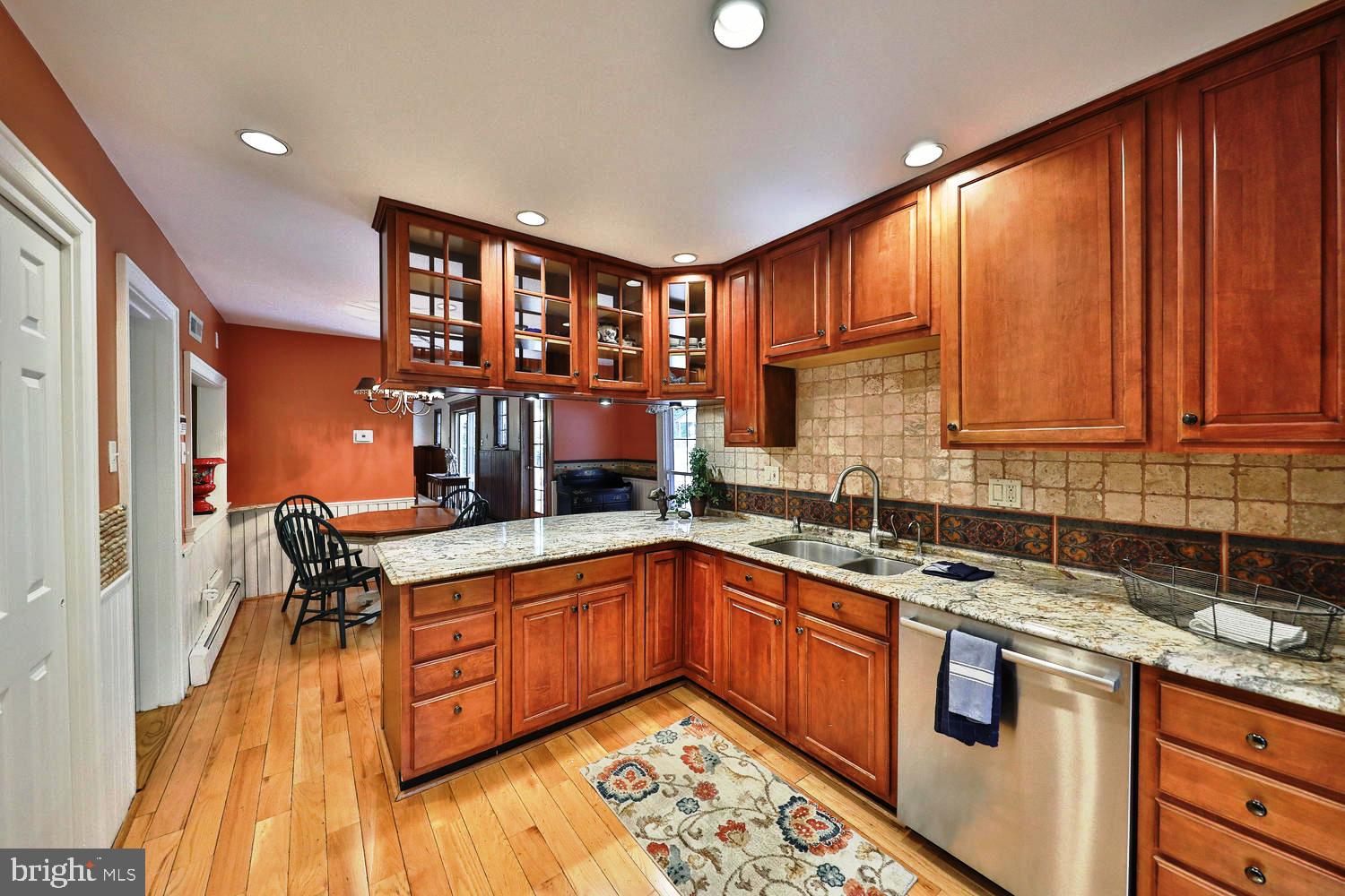 923 Rydal Road Jenkintown, PA 19046 - Photo 18 of 56 a kitchen with stainless steel appliances granite countertop wooden cabinets a sink and dishwasher a stove with wooden floor