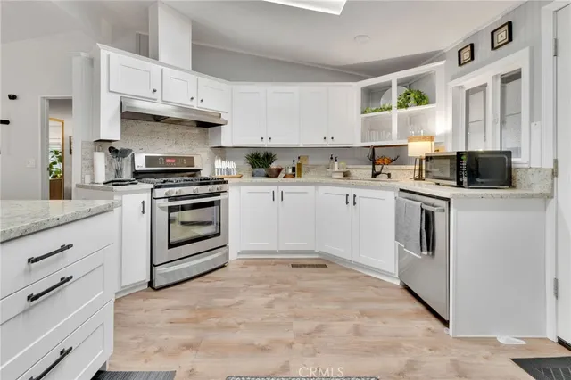 a kitchen with white cabinets and white appliances