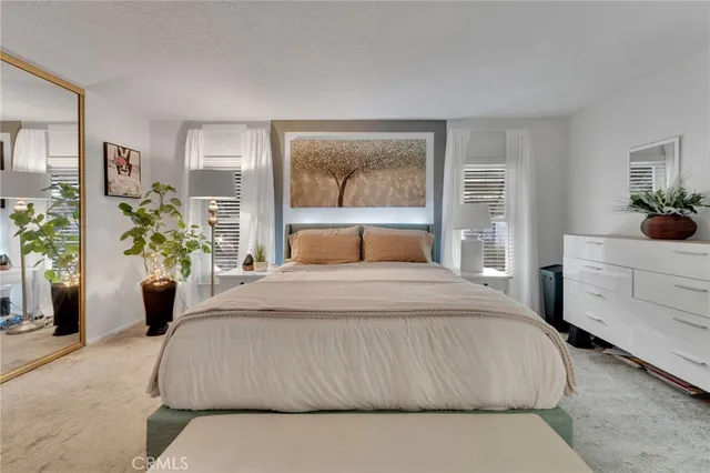 a bedroom with a large bed and a potted plant
