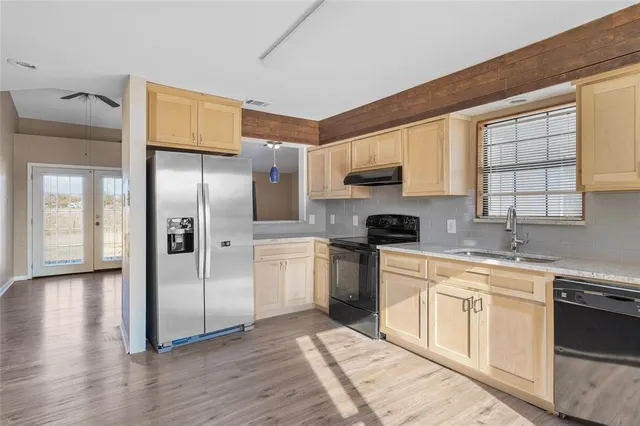 a kitchen with stainless steel appliances granite countertop a refrigerator sink and cabinets