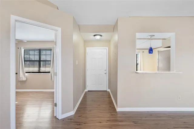 a view of a hallway with wooden floor and closet