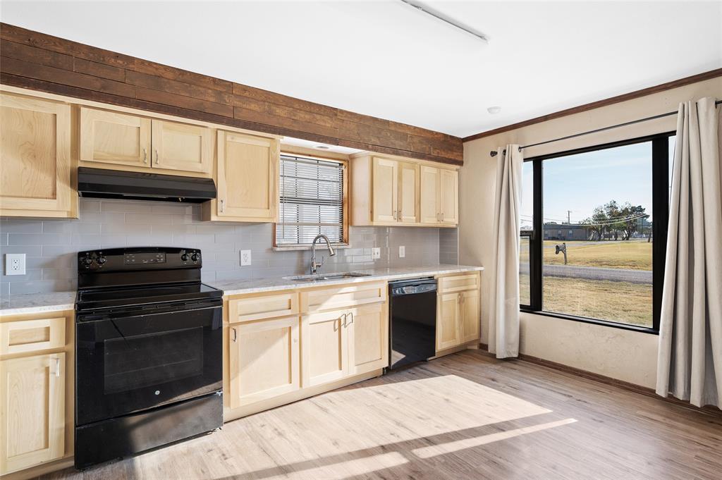 208 West Maple Street Gunter, TX 75058 - Photo 10 of 32 a kitchen with a stove a sink and a microwave