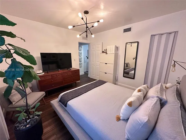 a bedroom with a bed and flat screen tv