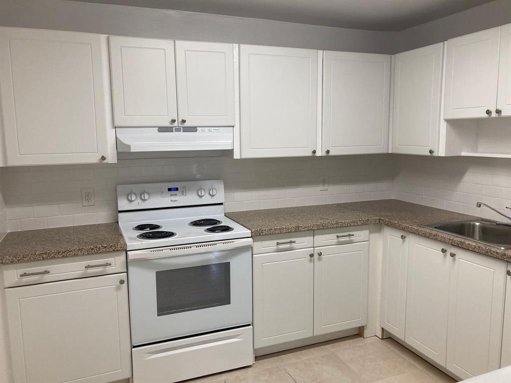 3600 Riverside Drive, Unit B Coral Springs, FL 33065 - Photo 6 of 9 a kitchen with granite countertop white cabinets and white appliances