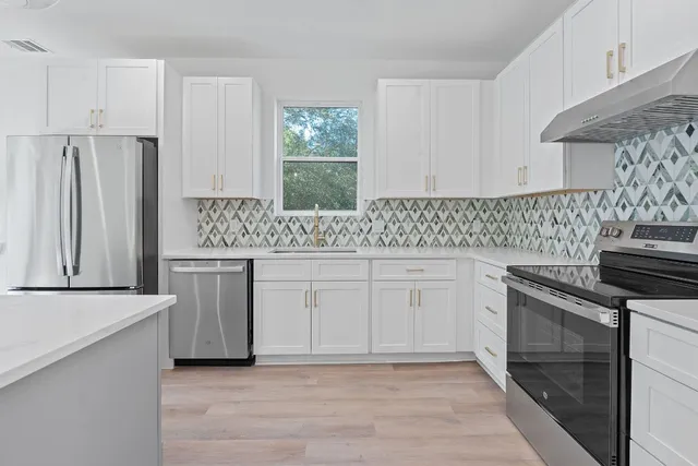 a kitchen with a stove and white cabinets