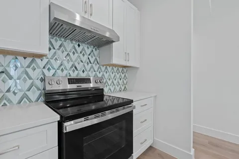 a kitchen with granite countertop a sink stove and cabinets