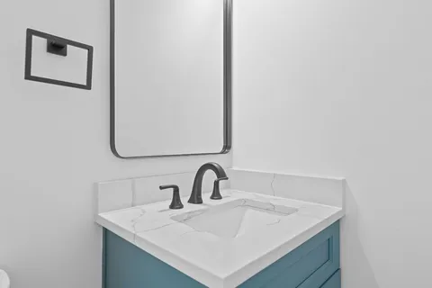 a bathroom with a toilet sink and mirror