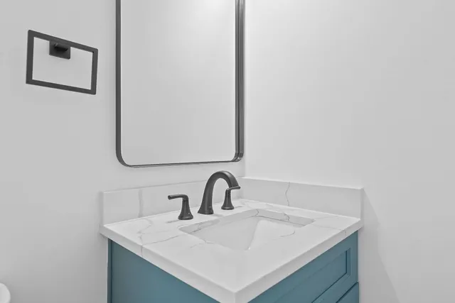 a bathroom with a toilet sink and mirror