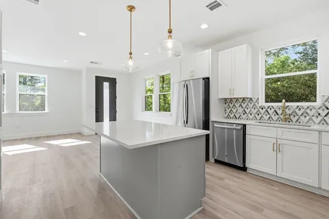 a kitchen with stainless steel appliances granite countertop a sink stove and refrigerator