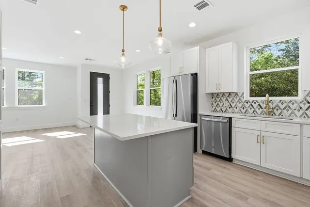 a kitchen with stainless steel appliances granite countertop a sink stove and refrigerator